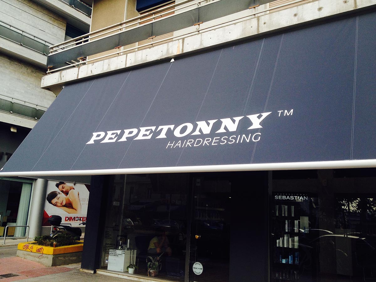 Τέντα με βραχίονες σε σύστημα μπάρας με βαμμένο εκτυπωμένο πανί σε κομμωτήριο pepetonny στην περιοχή του Γαλατσίου